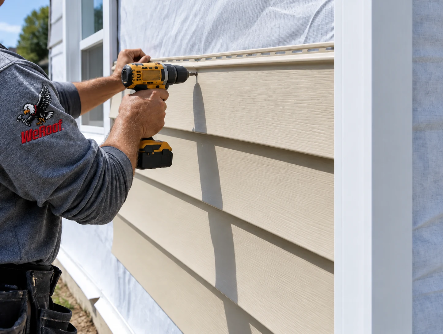 Illustrative siding installer fastening a vinyl panel, with a WeRoof logo added to the shirt sleeve
